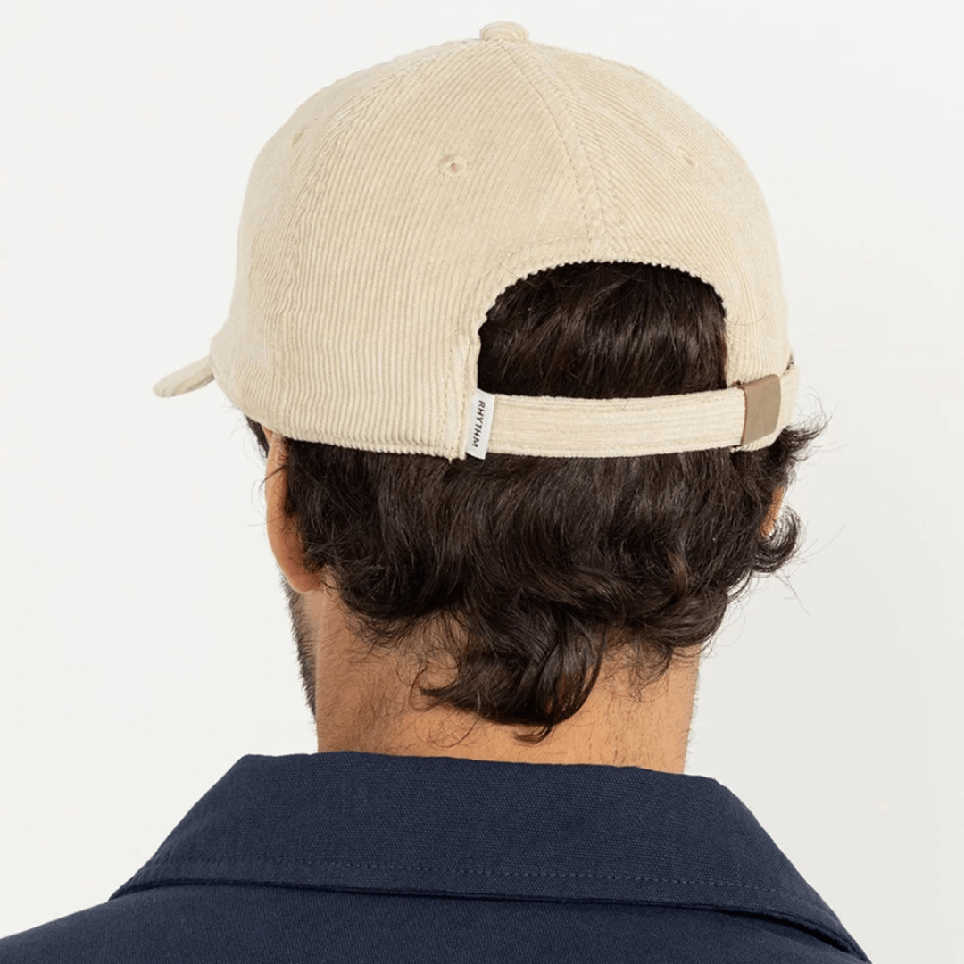 Lifestyle photo of model wearing oak coloured Rhythm cord cap (back view) available from Stewart's Menswear, Mullumbimby