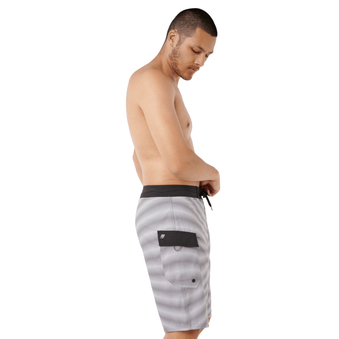Side View of model wearing Rip Curl Shock Wave Boardshort Cool Grey available at Stewart’s Menswear Mullumbimby. Men’s quick-dry DWR surf shorts with side pocket.