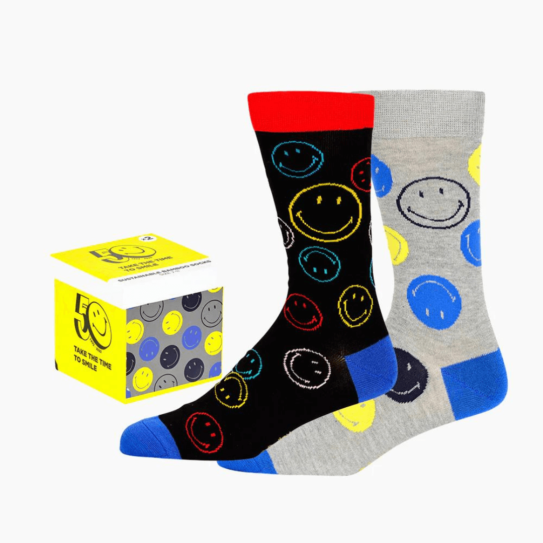 Stewarts Menswear Bamboozled socks 2 pack gift box. This Gift Box is the perfect gift, featuring two pairs of novelty crew socks packaged in a matching Gift Box.  Bamboozld Gift Boxes have a vibrant collection of quirky bamboo-blend socks which pack a playful punch. Theme is Smiley. Includes one x black socks and one by grey socks with smiley faces all over.