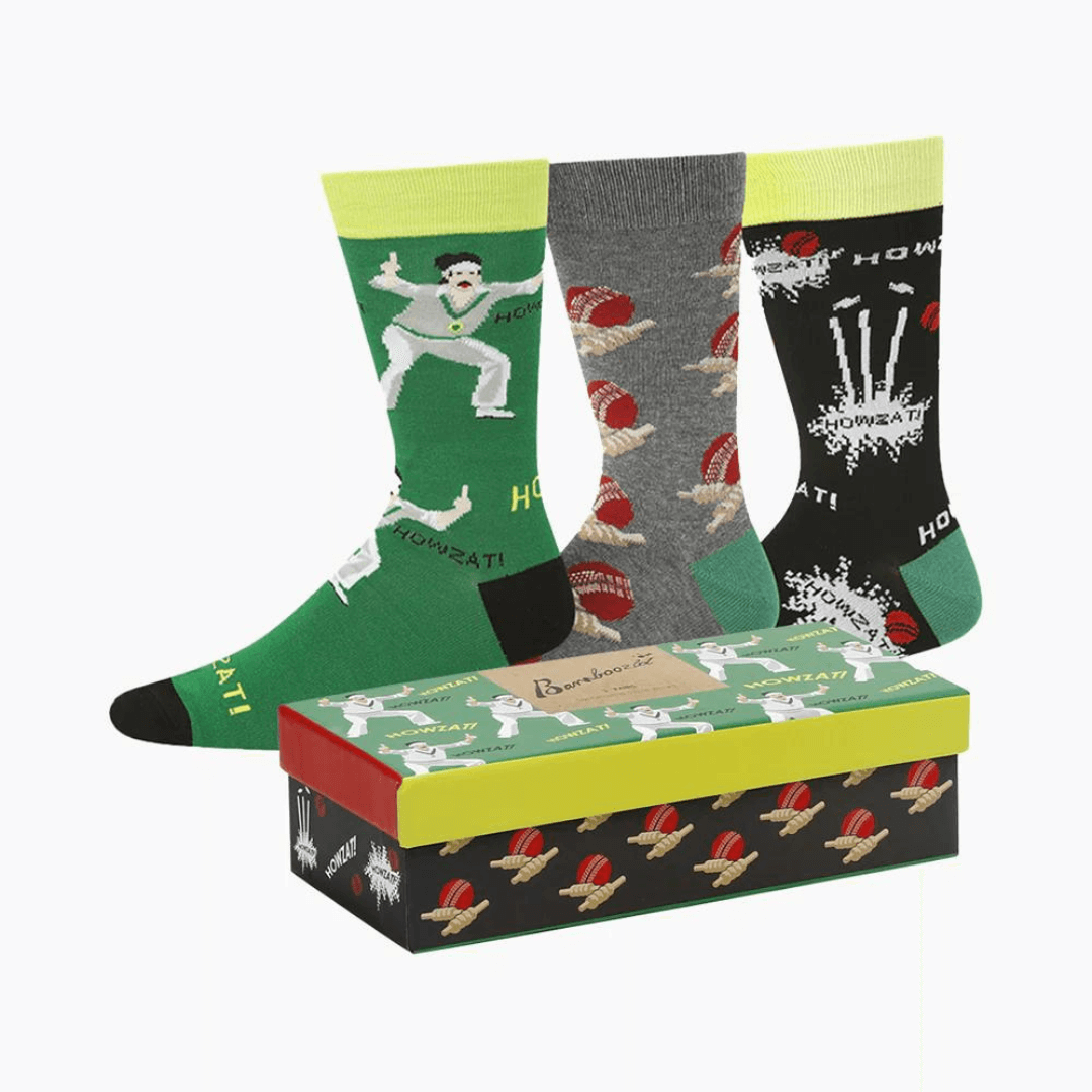 Stewarts Menswear Bamboozled socks 3 pack gift box. This Gift Box is the perfect gift, featuring three pairs of novelty crew socks packaged in a matching Gift Box. Bamboozld Gift Boxes have a vibrant collection of quirky bamboo-blend socks which pack a playful punch. Theme is cricket with one x green socks, 1 x grey socks and 1 x black socks featuring different cricket print on each pair.