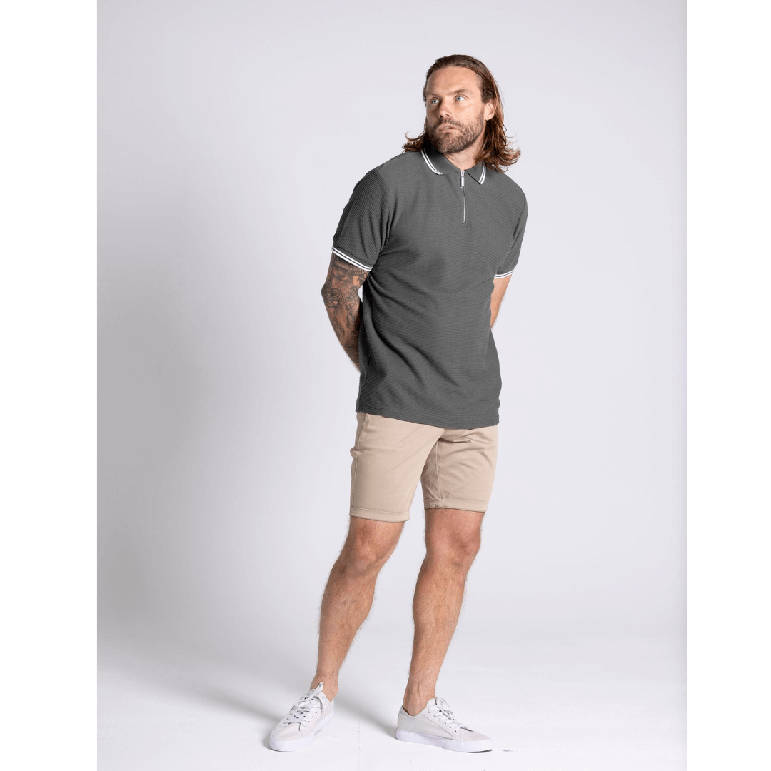 Stewart's Menswear Blackwood Apparel Heath Zip Polo. Its 1/2 zip front as opposed to buttons gives a casual sophistication. Colour is Khaki with white stripe trim on collar and sleeves. Photo shows model wearing Blackwood Heath Zip Polo. Front view