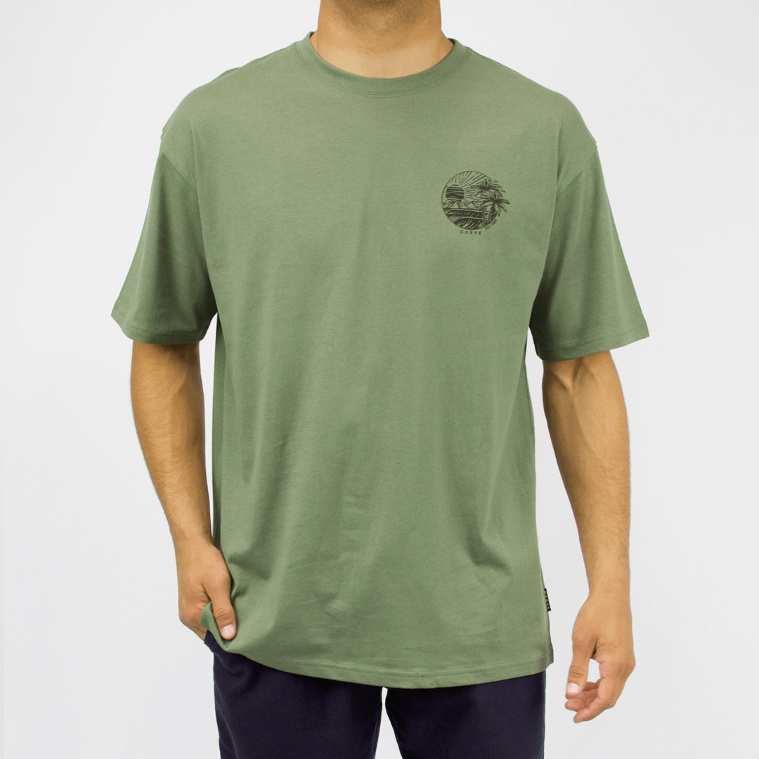 Carve Eventide Short Sleeve Tee is a relaxed cotton T-shirt with chest and back prints, S–5XL, available at Stewart’s Menswear Mullumbimby. Photo shows front view of Eventide T-shirt showing small left chest print. Moss Green Colour with black print.