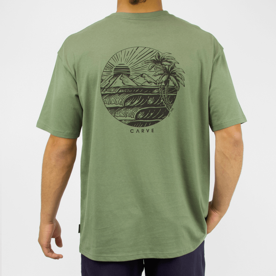 Carve Eventide Short Sleeve Tee is a relaxed cotton T-shirt with chest and back prints, S–5XL, available at Stewart’s Menswear Mullumbimby. Photo shows back view of Eventide T-shirt showing large surf inspired graphic print. Moss Green Colour with black print.
