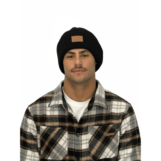 Model wearing Carve Havoc Beanie in black available at Stewart’s Menswear Mullumbimby. Rib knit cuff beanie with PU leather badge on the front.