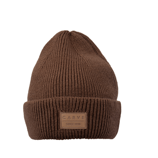 Stewarts Menswear Carve Surf wear Havoc Beanie. Colour is tobacco. The trendy beanie from Carve Surf brand will ensure you stay warm and on trend in the cooler months. Made from a soft acrylic yarn, this beanie features a  pleather badge on the front.  The classic beanie shape provides ample coverage for your ears and forehead.