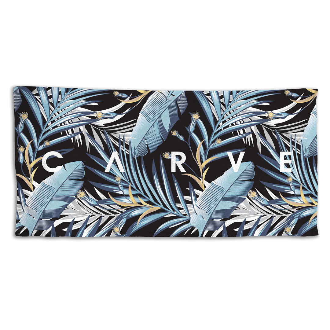 Stewarts Menswear Carve Surfwear Under The Palms Beach Towel. Made from 100% cotton with velour one side, this beach towel has superior absorbency and comfort. All over palm tree and feather print in dark and light blue shades.