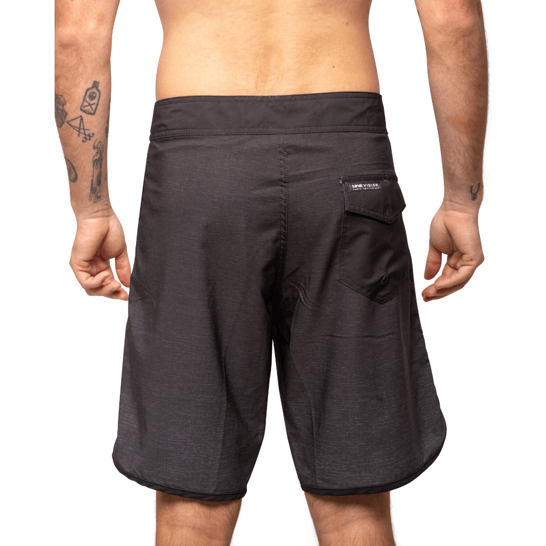 Stewarts Menswear Liive Vision Apparel Vague Boardshort. Trendy gradient colour design. Fitted waist with drawcord, back patch pocket with velcro closure and keep loop in the back pocket. Dark black waistband with gradient black body. Scalloped leg with black piping and black pocket on back. Back View.