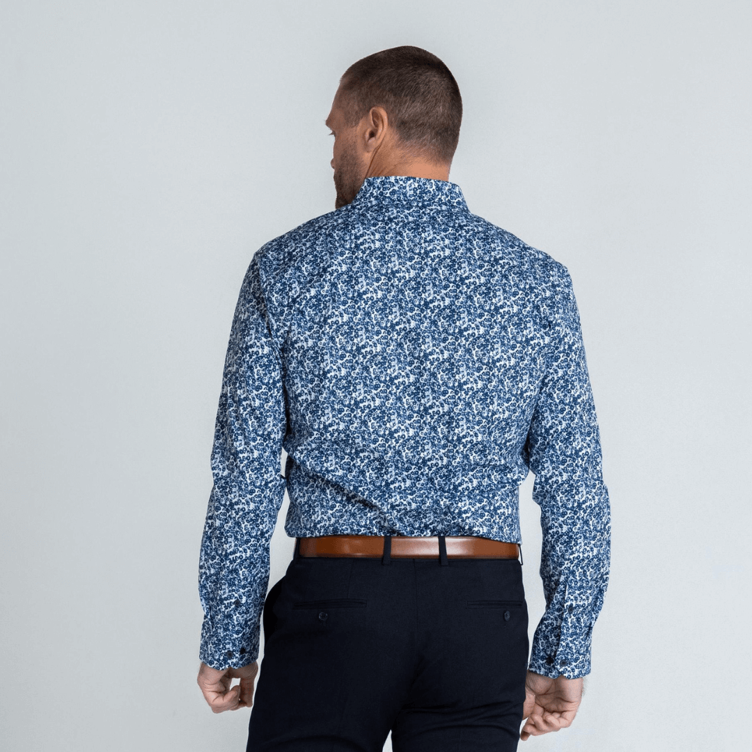 Stewart's Menswear, Mullumbimby. Photo shows model wearing Dale long sleeve shirt from Blackwood Apparel. Back View. Colour is white with tiny floral print all over in shades of Navy and grey.