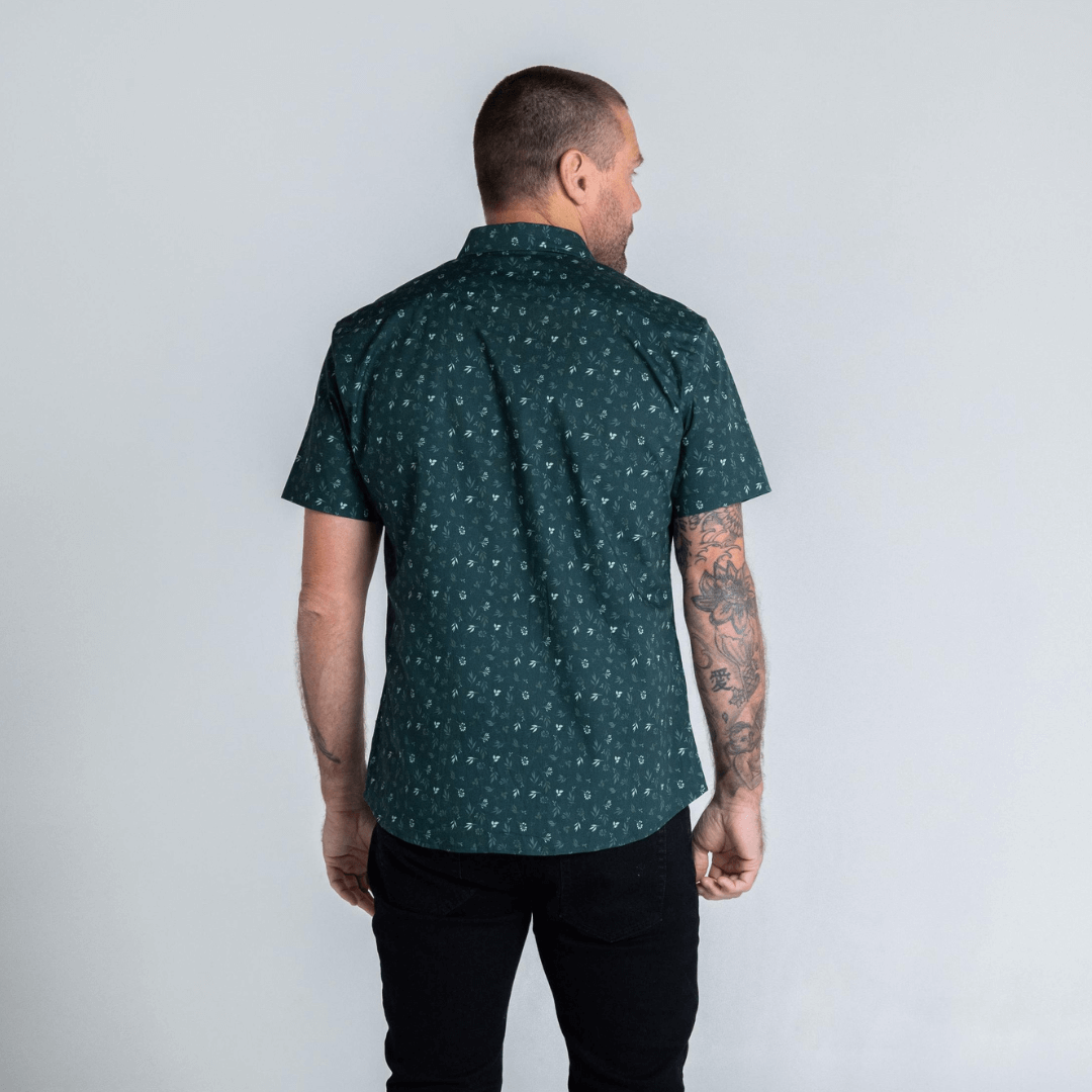 Stewart's Menswear, Mullumbimby. Photo shows model wearing Glass Short Sleeve shirt by Blackwood apparel. Back View. Colour is dark green with small floral print in lighter contrasting green colours.