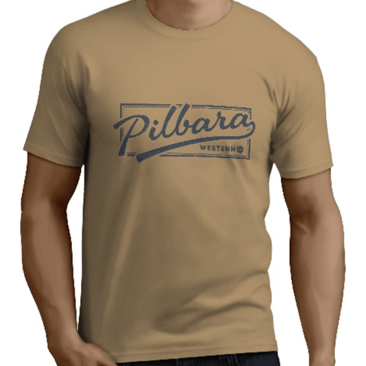 Stewarts Menswear Mullumbimby. Pilbara Western Men's T-shirt. Photo shows model wearing Pilbara Western Game Day Tee. Colour is called golden rough ( a light tan colour) featuring a navy coloured vintage style print "Pilbara Western"