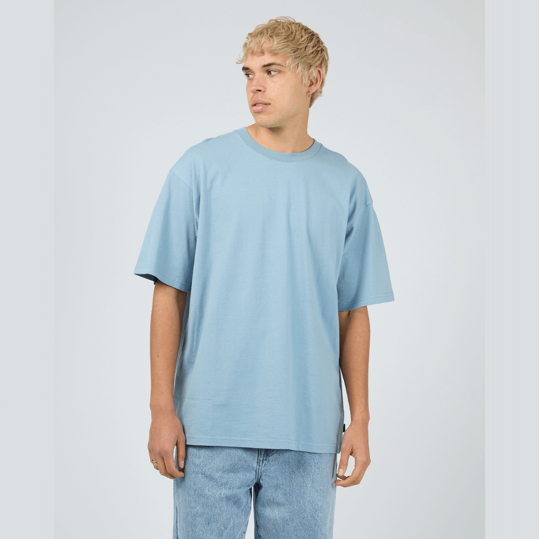 Front view of model wearing blue Silent Theory Essential Tee available at Stewart’s Menswear Mullumbimby. Men’s relaxed fit 100% cotton tee with crew neck and short sleeves.