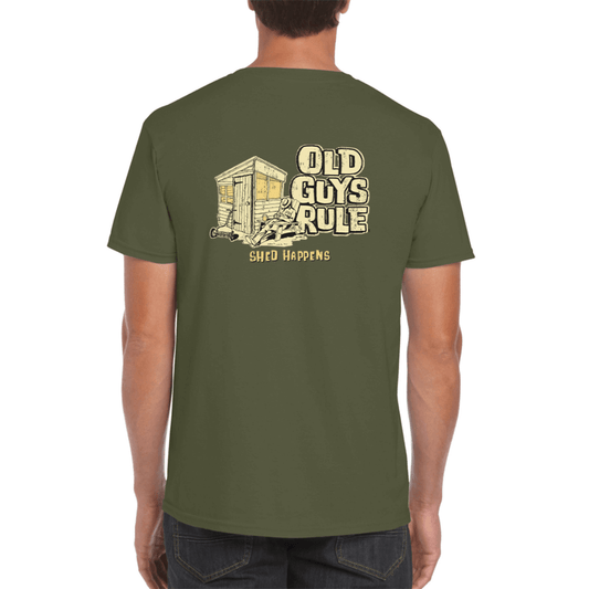 A man wearing a green t-shirt with the text 'OLD GUYS RULE SHED HAPPENS' on the back in bold letters, and a smaller print of the same text on the front.