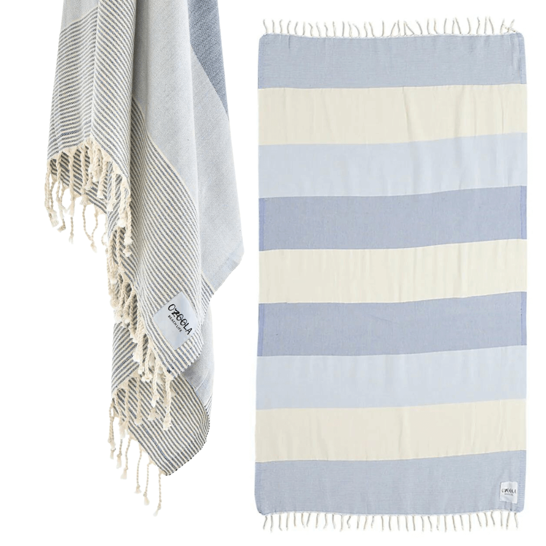 Stewarts Menswear Ozoola Johnny Towel. The Johnny Towel is made from 100% Turkish Cotton which is super absorbent and fast drying. Sized at 180 x 100cm with knotted fringing at each end. Ideal for endless beach days, and lazy pool days. Soft and light, it is perfect for travelling and it can also be used as a sarong. Colour is Natural Blue with wide stripes of constrast colours.