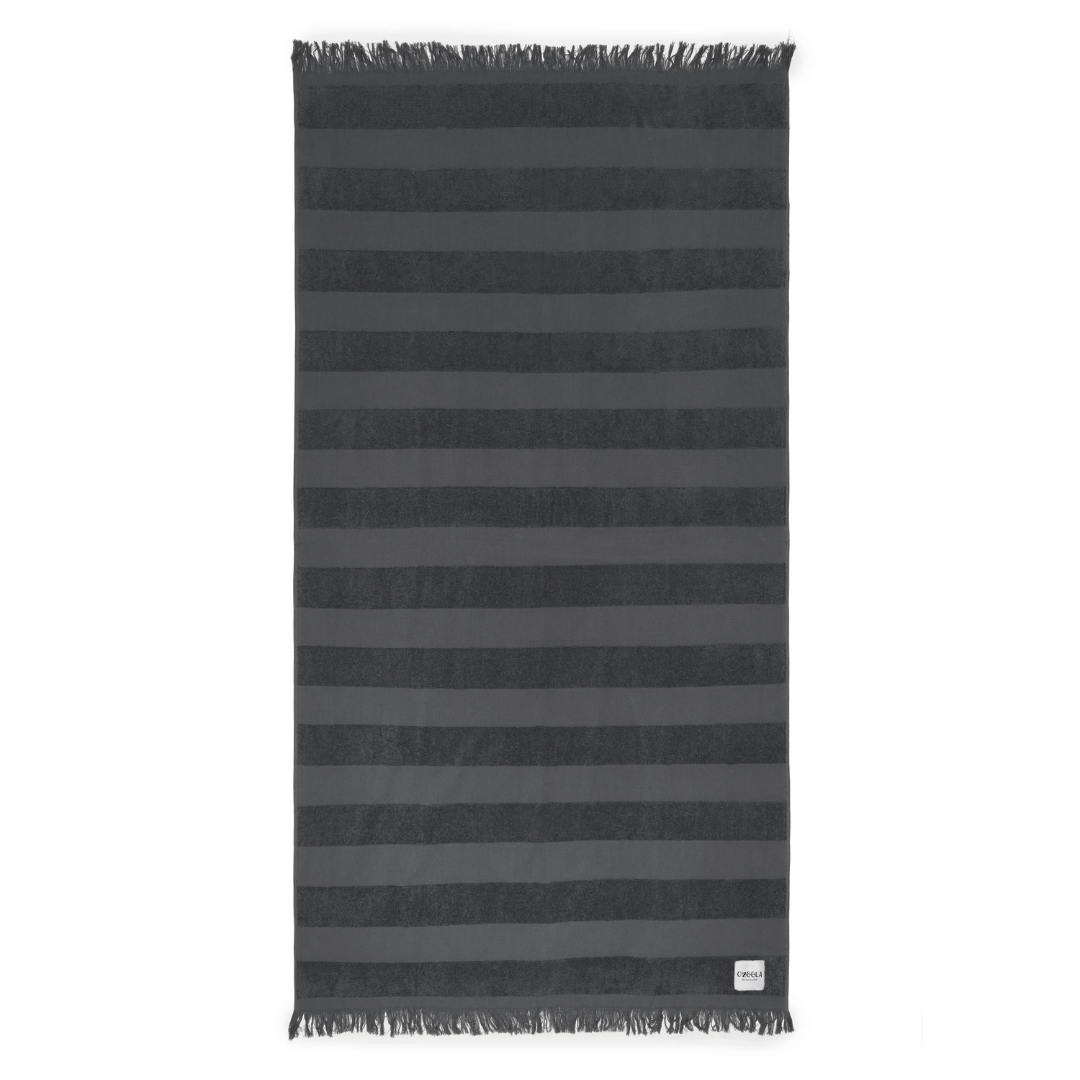 Stewarts Menswear Ozoola Pool to Beach towel.The newest addition to the OZoola Beach Towels range is the Pool to Beach towel. Perfect for endless beach days, lazy pool days, and travelling. Soft and light, this towel features a combination the very popular Turkish Cotton towels with the addition of terry stripes to keep you dry in style. Colour is Rocky (a Charcoal grey colour).