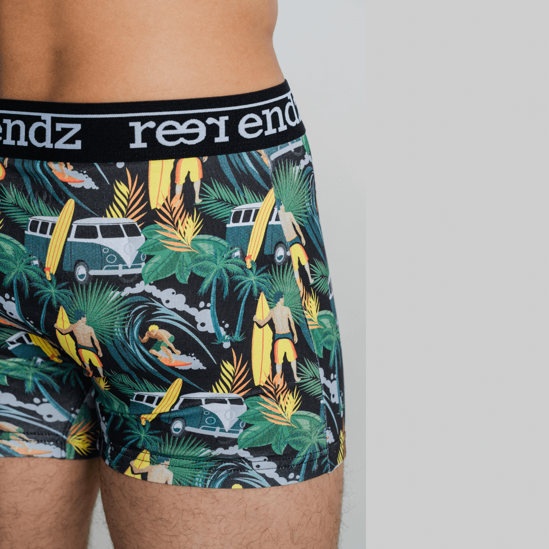 Stewarts Menswear Reer Endz organic cotton underwear. Offshore Vibes is a leafy green background trunk with combis, surfers and surfboards printed all over. Photo shows close up of model wearing Offshore Vibes Reer Endz Underwear.