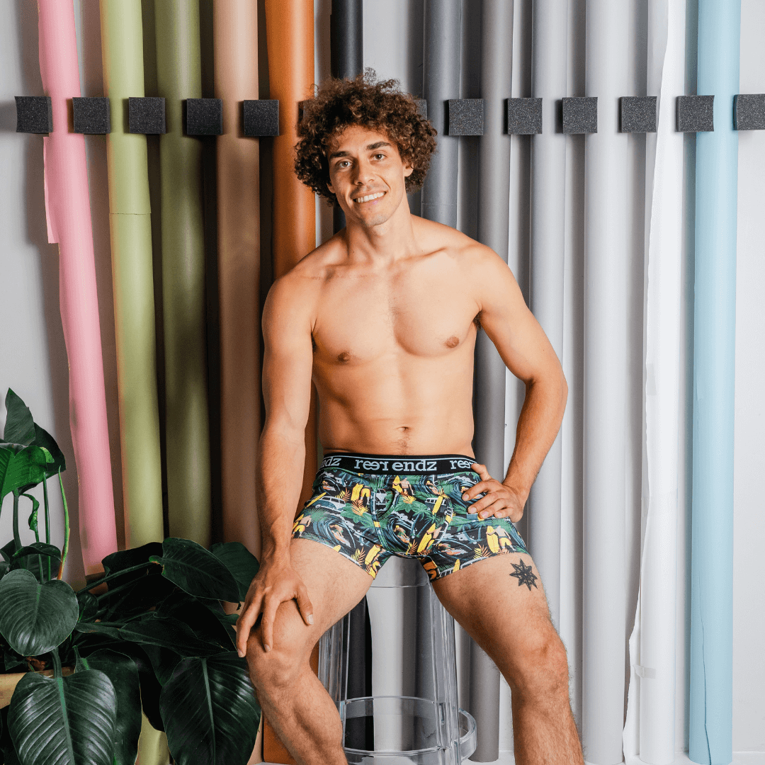 Stewarts Menswear Reer Endz organic cotton underwear. Offshore Vibes is a leafy green background trunk with combis, surfers and surfboards prined all over. Photo shows model wearing Offshore Vibes Reer Endz Underwear.
