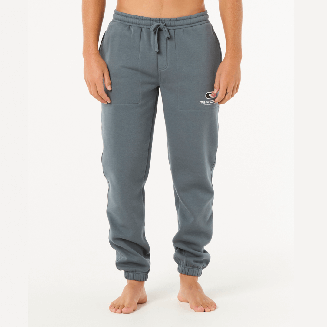 Stewart's Menswear, Mullumbimby. Rip Curl Icons of Surf Track pant. Photo shows model wearing Rip Curl Icons of Surf Track Pant, front view. Colour is Pine with side pockets and Rip Curl logo on leg. Elastic waist and elastic cuffs at ankles.