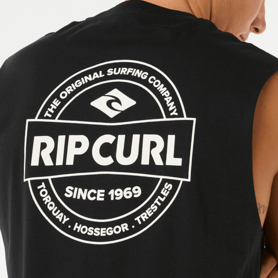 Stewarts Menswear, Mullumbimby. Rip Curl Stapler Muscle Tee. Colour is black. Small Rip Curl logo on front and larger logo on back. Photo shows model wearing Rip Curl Stapler Muscle Tee, back close up view.