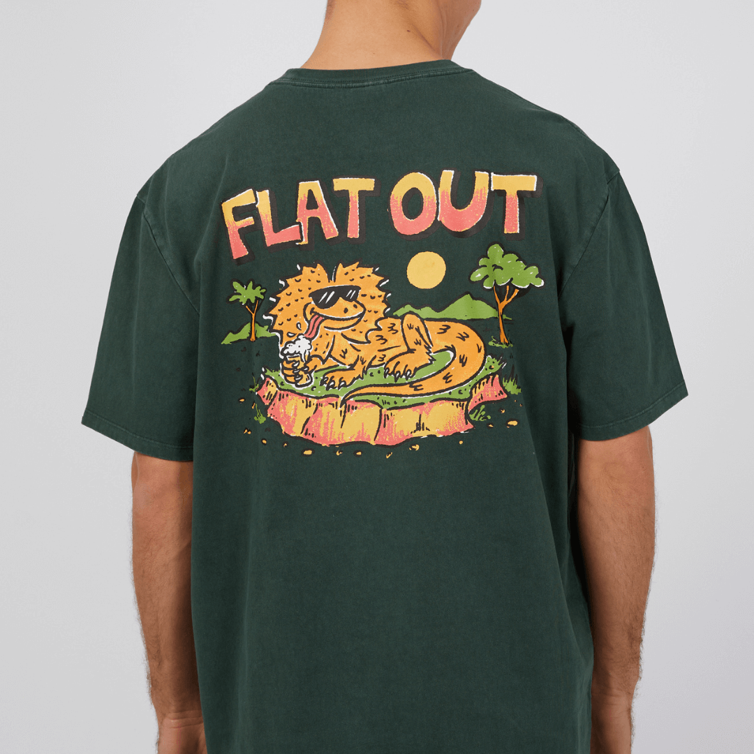 Stewarts Menswear St Goliath Flat Out Tee. Made with 100% cotton for cool comfort, this short sleeve tee isn't just clothing; it's a sensation.  Large print on the back depicts a lizard drinking, just like the old saying "Flat Out Like a Lizard Drinking." The same image is repeated as a small image on front Left side. Colour is Bottle Green. Photo shows close up of back print.