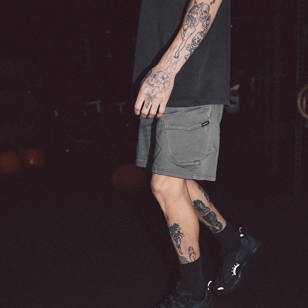Stewarts Menswear St Goliath Gully Cargo shorts. The inset cargo pockets, waist band, and side pockets make these hybrid denim shorts a must-have for any adventure. Photo shows model wearing St Goliath Gully Cargo Short. Lifestyle photo at night.