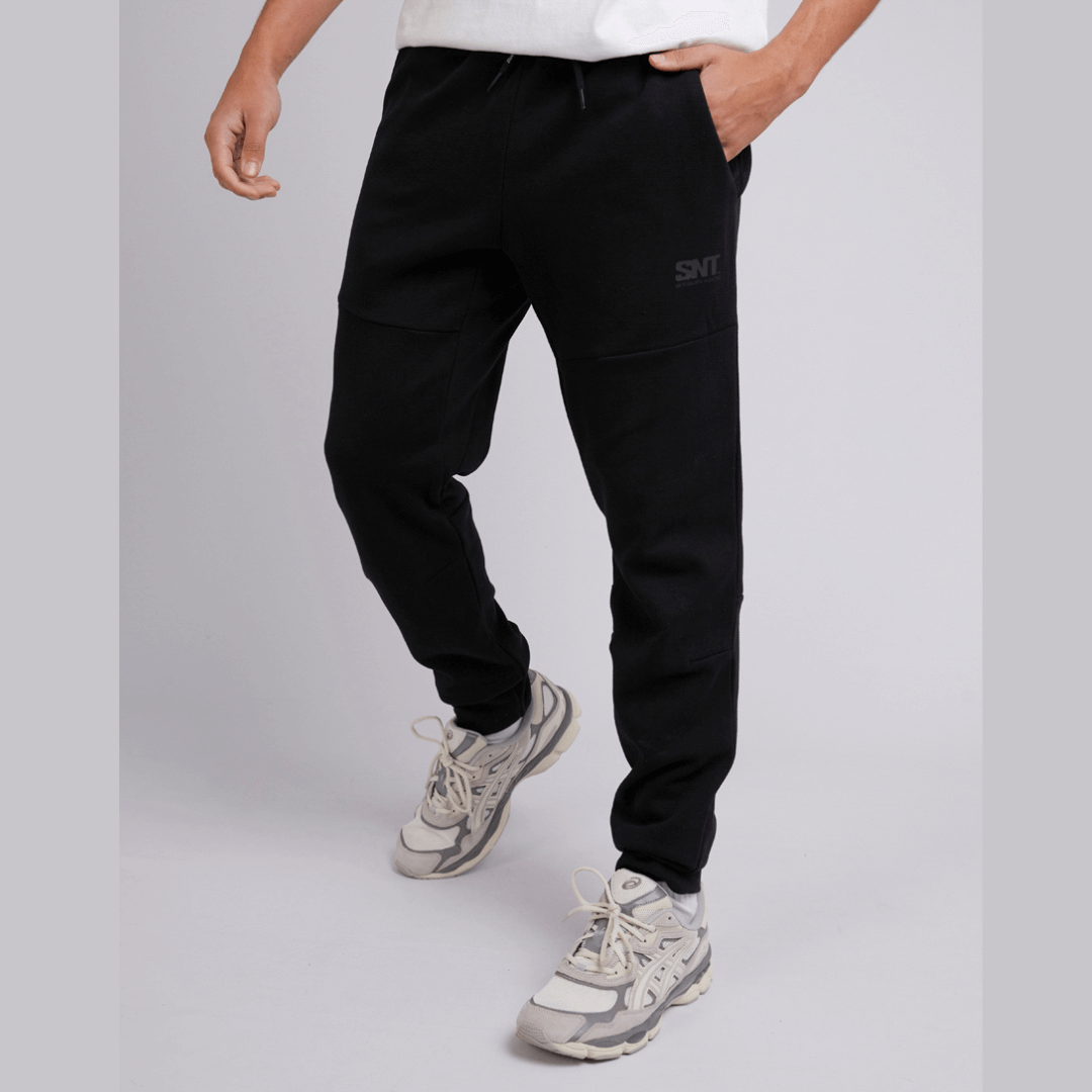 Stewarts menswear mullumbimby, St Goliath Tech Track pant. Colour is Black. Cuffed legs, black St Goliath logo on front side pocket. Photo shoes front view