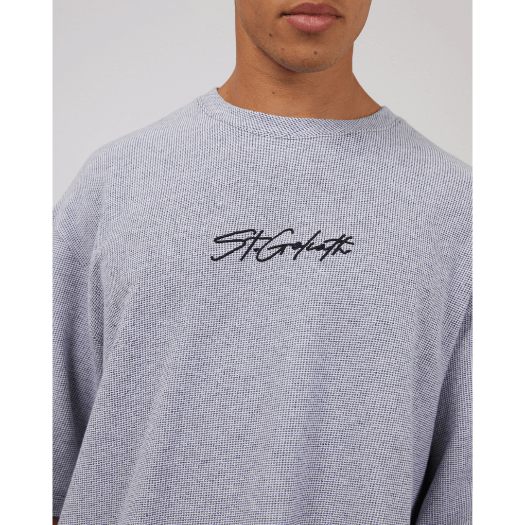 Stewarts Menswear St Goliath Texture Tee. A light coloured t-shirt featuring St Goliath logo embroidered in black. Photo shows model wearing St Goliath Texture Tee, close up view.