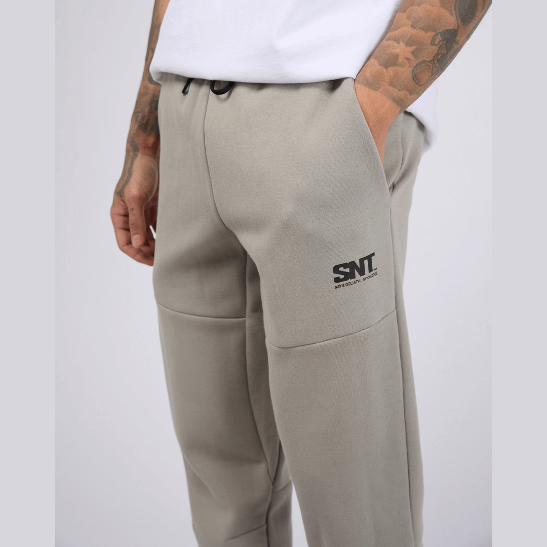Stewarts menswear mullumbimby, St Goliath Tech Track pant. Colour is grey marle. Cuffed legs, black St Goliath logo on front side pocket. Photo shows close up front view