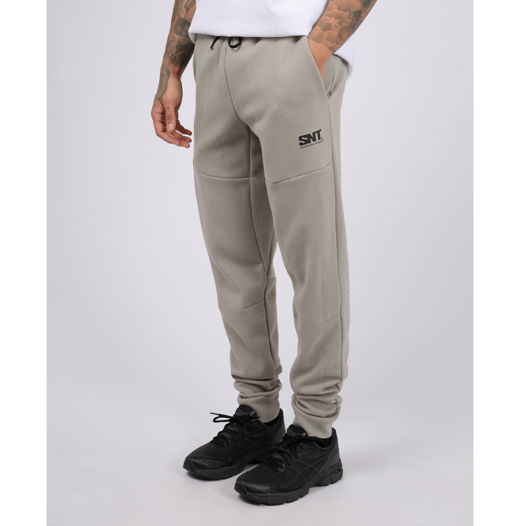 Stewarts menswear mullumbimby, St Goliath Tech Track pant. Colour is grey marle. Cuffed legs, black St Goliath logo on front side pocket. Photo shoes front view.