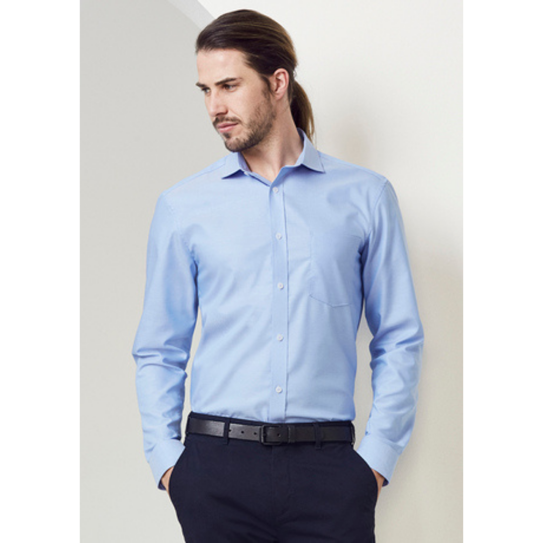 Model wearing Regent long sleeve shirt. Colour is light blue. Fabric is cotton.