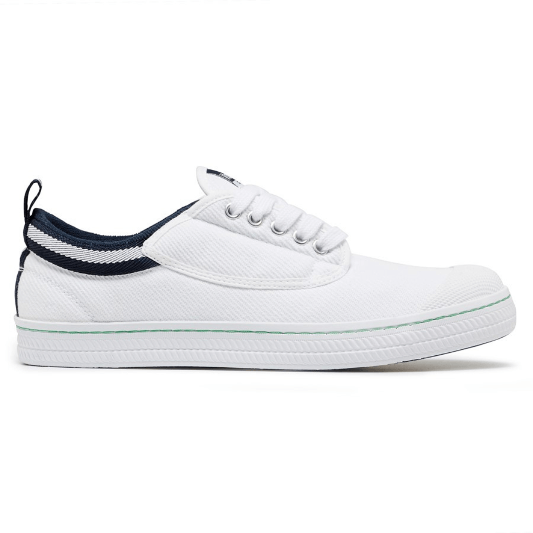 Stewart's Menswear Dunlop Volley Classic shoe. Whether you're dressing up or down, Dunlop Volleys are versatile and will add retro style to your outfit. The simple design features a canvas upper with a moulded rubber toe cap and a contrasting stripe on the side. The shoe's original herringbone rubber outsole is slip resistant and non-marking. White side view.