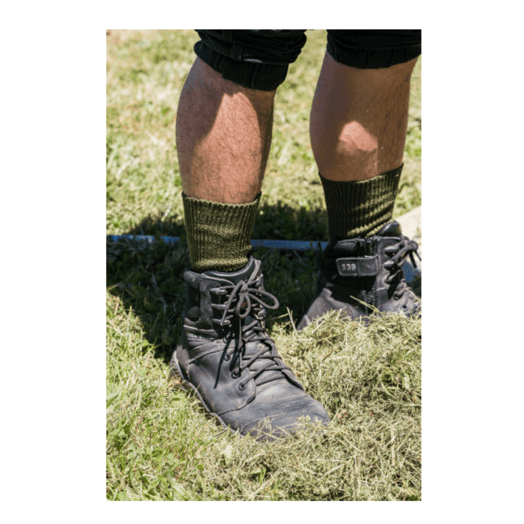 Stewarts Menswear Humphrey Law Australian Made socks, the Grass Seed sock, an absorbant and hardwearing sock, excellent in boots and gum boots. Made from a unique cotton blend, the Grass Seed Sock is knitted with a thick, slippery cotton yarn that allows grass seeds and sawdust to slip off. Extra reinforcing in the heel and toe, make them even more hard-wearing and long-lasting and true rib top provides sideways stretch. Lifestyle photo of worker wearing Grass Seed socks in work boots.