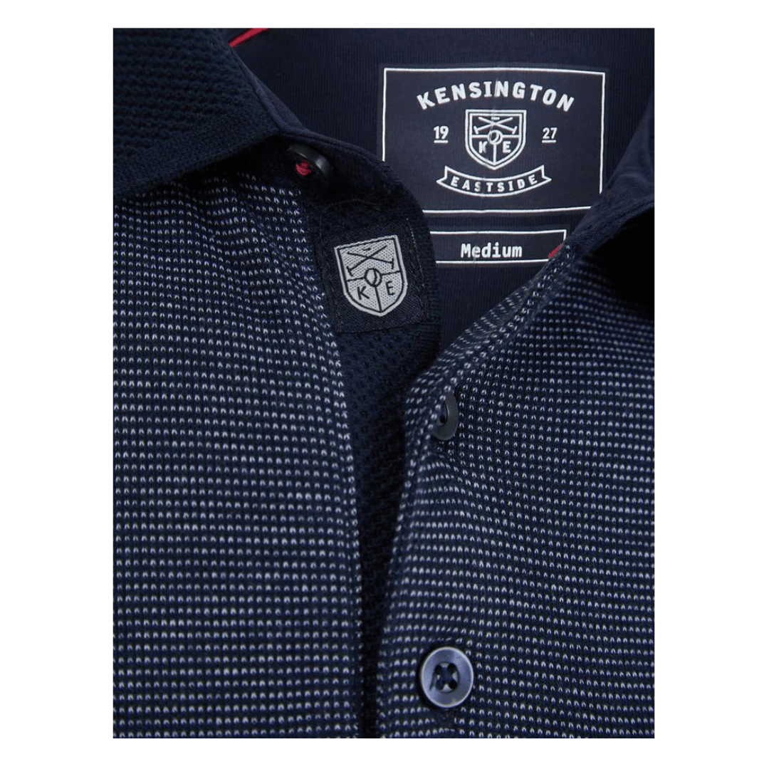 Stewart's Menswear, Mullumbimby, Kensington Bardell Polo Shirt. polo shirt has a classic silhouette with a 3-button placket and short sleeves with cuffs. It's made of 100% cotton with a birdseye design for texture and comfort, and has a matching jacquard pattern collar and a chest pocket with button fastening. The shirt has a subtle metal decal at the hem and two small side slits. Front button opening view of Navy Blue coloured Polo.