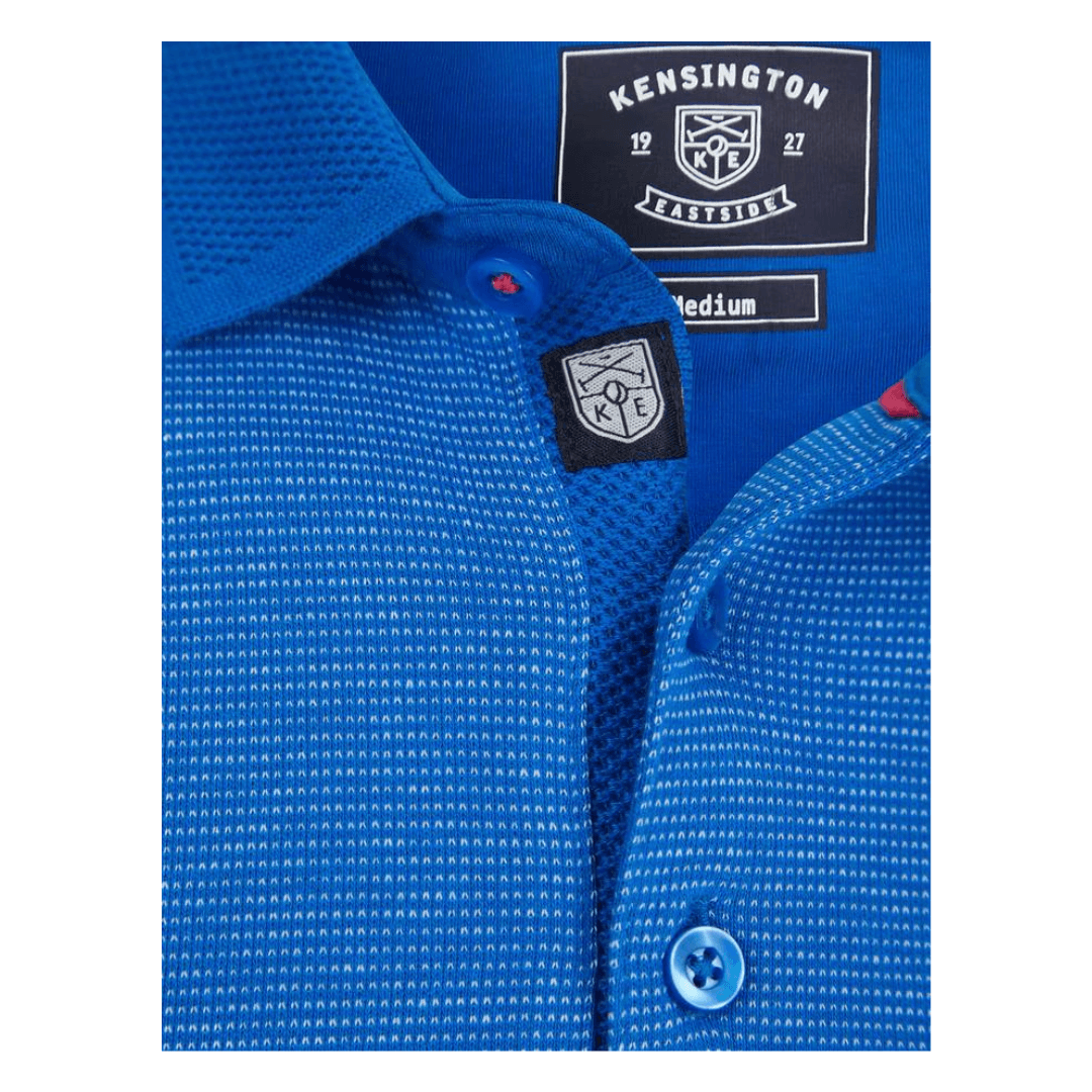 Stewart's Menswear, Mullumbimby, Kensington Bardell Polo Shirt. polo shirt has a classic silhouette with a 3-button placket and short sleeves with cuffs. It's made of 100% cotton with a birdseye design for texture and comfort, and has a matching jacquard pattern collar and a chest pocket with button fastening. The shirt has a subtle metal decal at the hem and two small side slits. Front button opening view of Royal Blue coloured Polo.