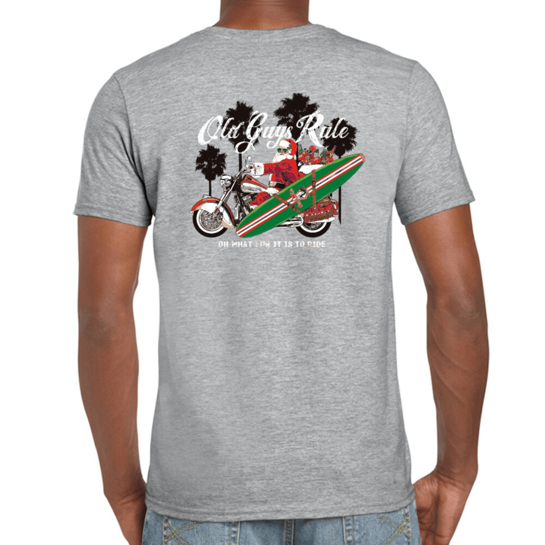Stewart's Menswear OLD GUYS RULE ~ Oh what fun it is to ride! A fun Christmas slogan and the perfect Christmas gift for any man who enjoys wearing their personality and showing their confident style! Perfect for the "Old Guy" in your life, give them a tee shirt they’ll wear and wear! Understated and classy, the big, loud message is on the back and a smaller print version is on the front. Fun print, Red Santa on red/black motorbike with green/red surfboard. Grey colour t-shirt.