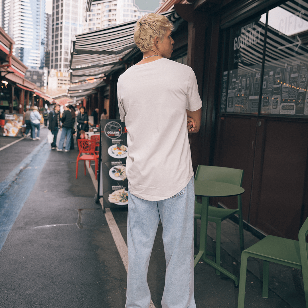 Stewarts Menswear, Mullumbimby. Photo shows photo of model in a city street wearing Silent Theory Solid Tail Tee. Colour is Tan