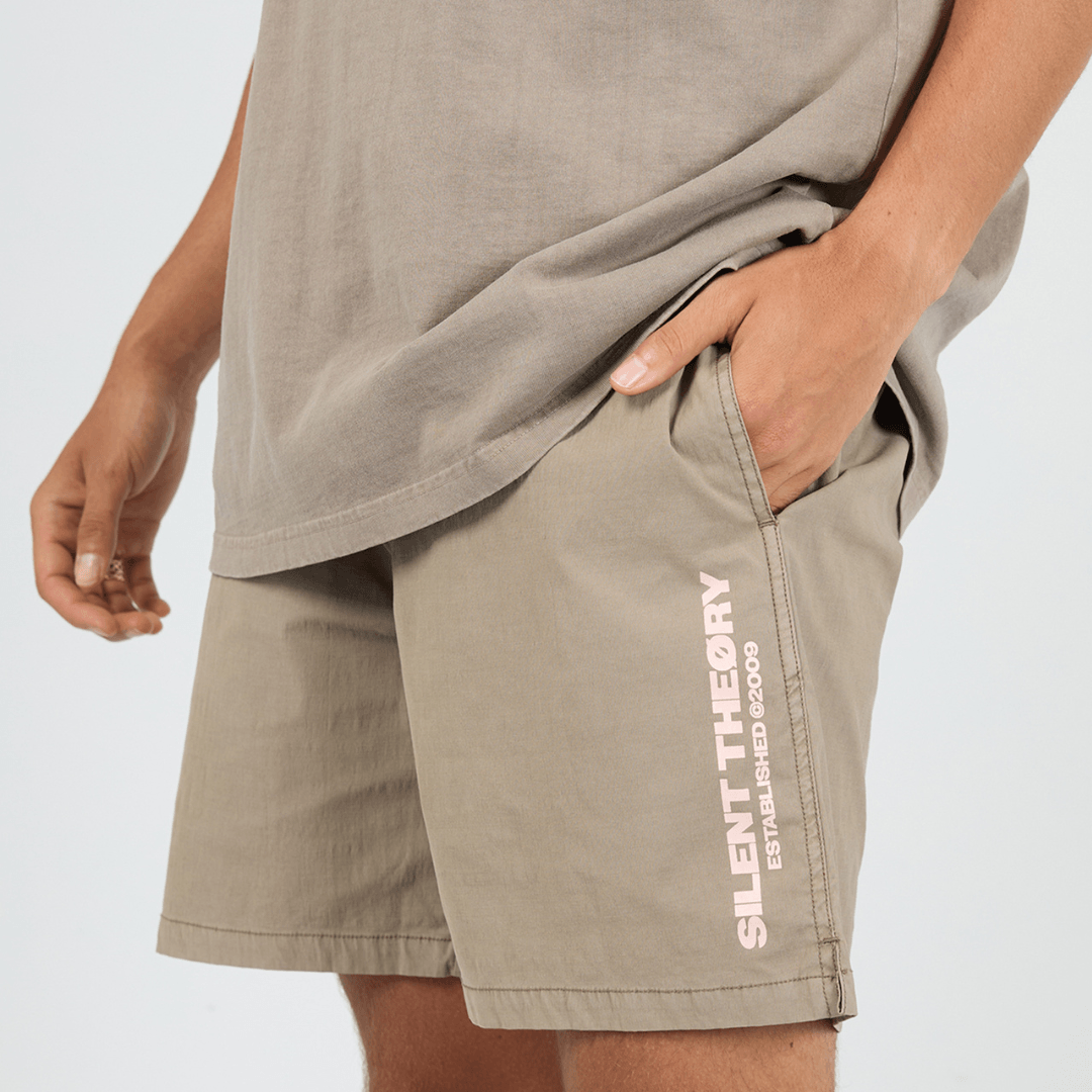Close up view of Silent Theory Essential Theory Swim Short in latte with vertical logo print on the leg, men's swim shorts available at Stewart's Menswear Mullumbimby.