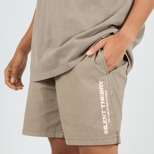 Close up view of Silent Theory Essential Theory Swim Short in latte with vertical logo print on the leg, men's swim shorts available at Stewart's Menswear Mullumbimby.