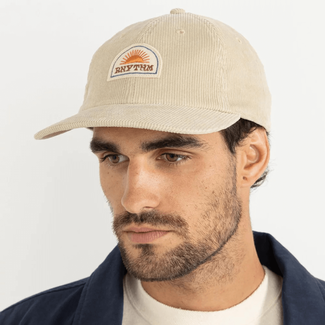 Lifestyle photo of model wearing oak coloured Rhythm cord cap (front view) available from Stewart's Menswear, Mullumbimby