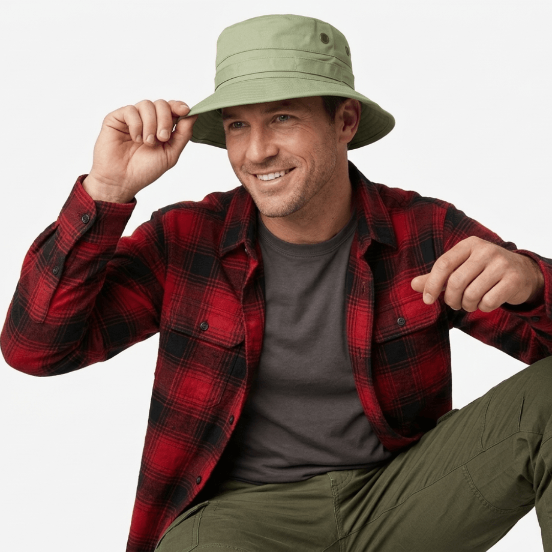 Man wearing a red plaid flannelette shirt, gray t-shirt, and green bucket hat on a white background. Avenel hats bush hat available from Stewart's Menswear, Mullumbimby.