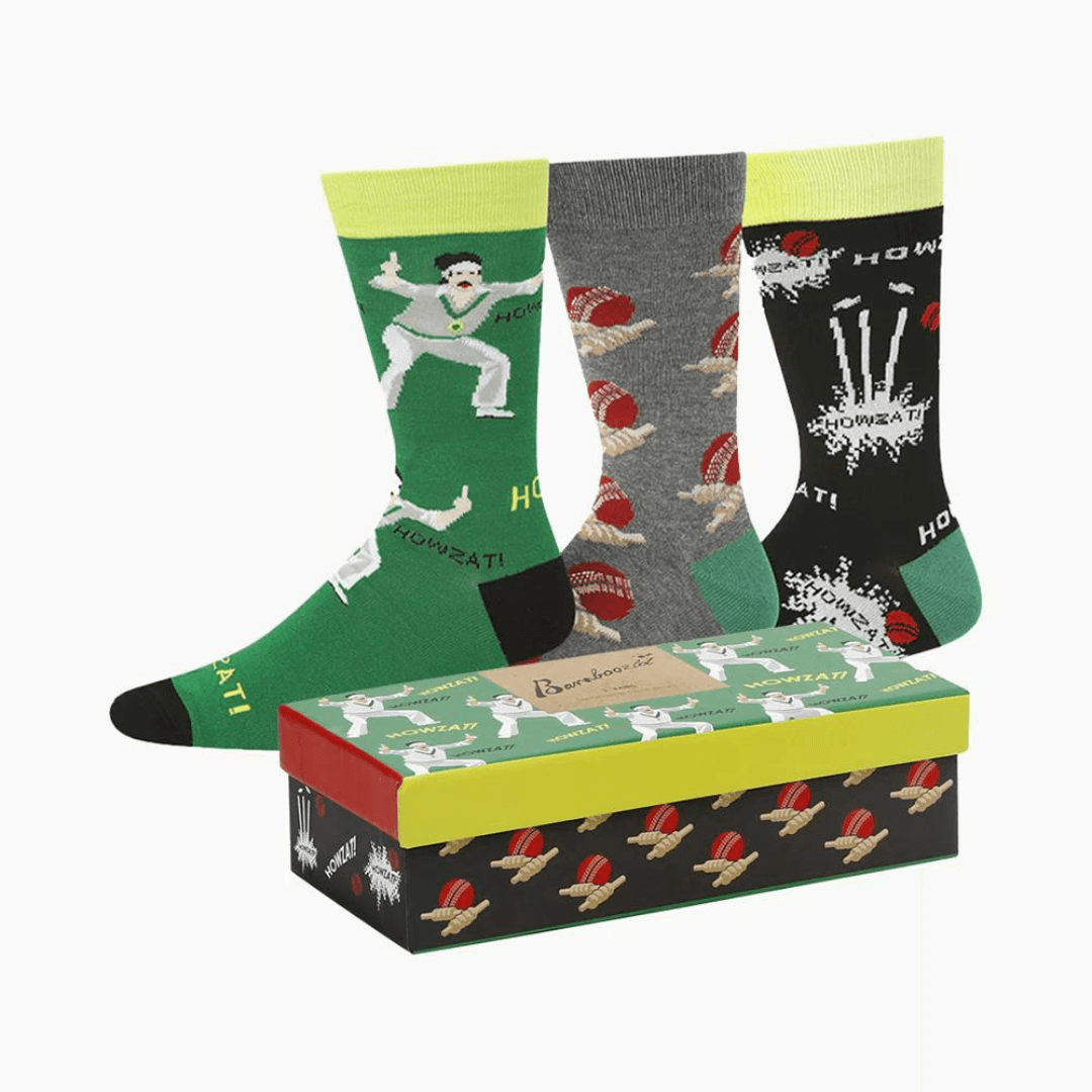 Stewarts Menswear Bamboozled socks 3 pack gift box. This Gift Box is the perfect gift, featuring three pairs of novelty crew socks packaged in a matching Gift Box.  Bamboozld Gift Boxes have a vibrant collection of quirky bamboo-blend socks which pack a playful punch. Theme is cricket with one x green socks, 1 x grey socks and 1 x black socks featuring different cricket print on each pair.
