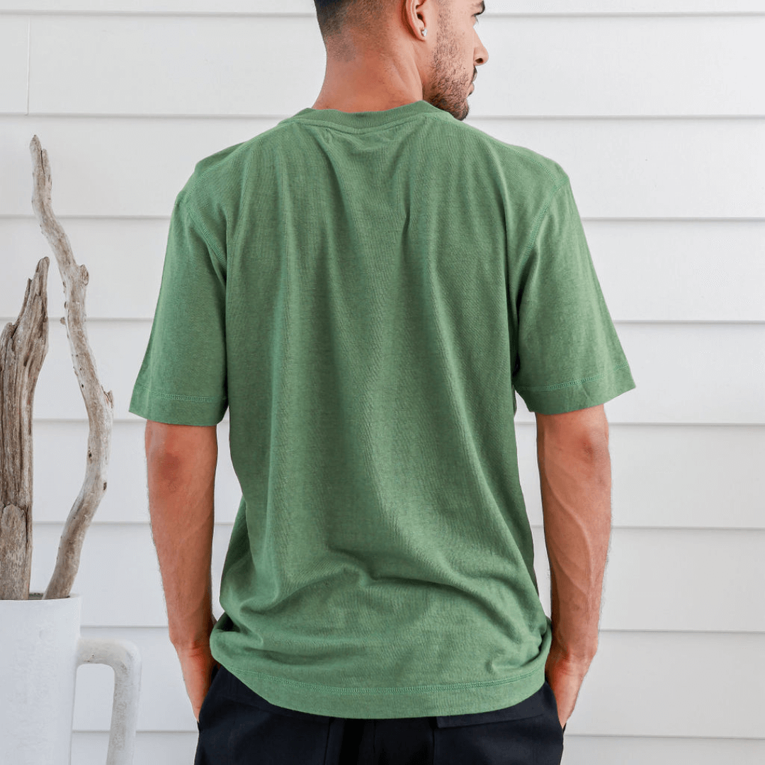 Stewarts Menswear Braintree Hemp. Hemp/Cotton button t-shirt. Hemp/Cotton short sleeve button tee is made from 55% Hemp and 45% Cotton and features a wide placket with two buttons. Photo shows model wearing green shirt - back view.