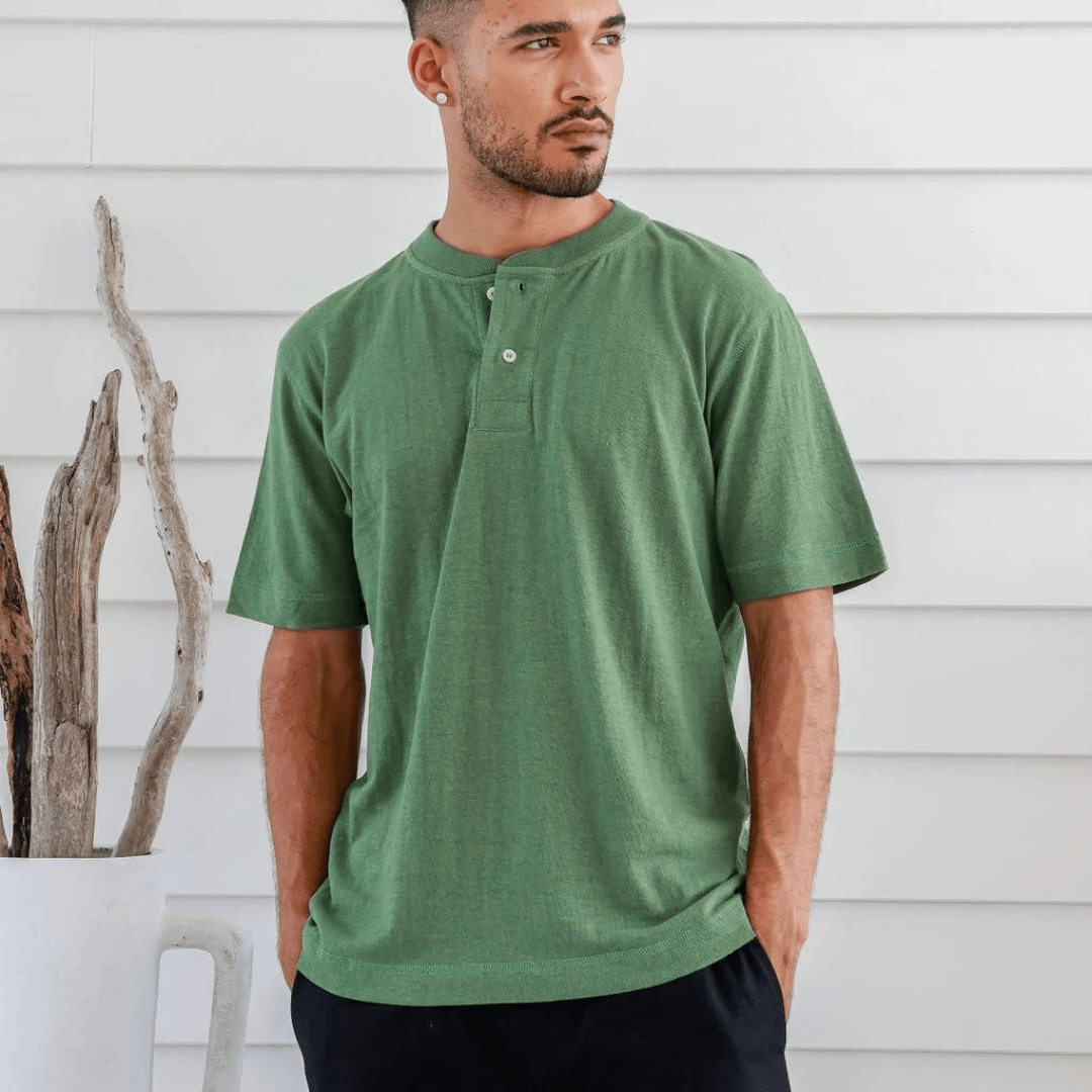 Stewarts Menswear Braintree Hemp. Hemp/Cotton button t-shirt. Hemp/Cotton short sleeve button tee is made from 55% Hemp and 45% Cotton and features a wide placket with two buttons. Photo shows model wearing green shirt - front view.
