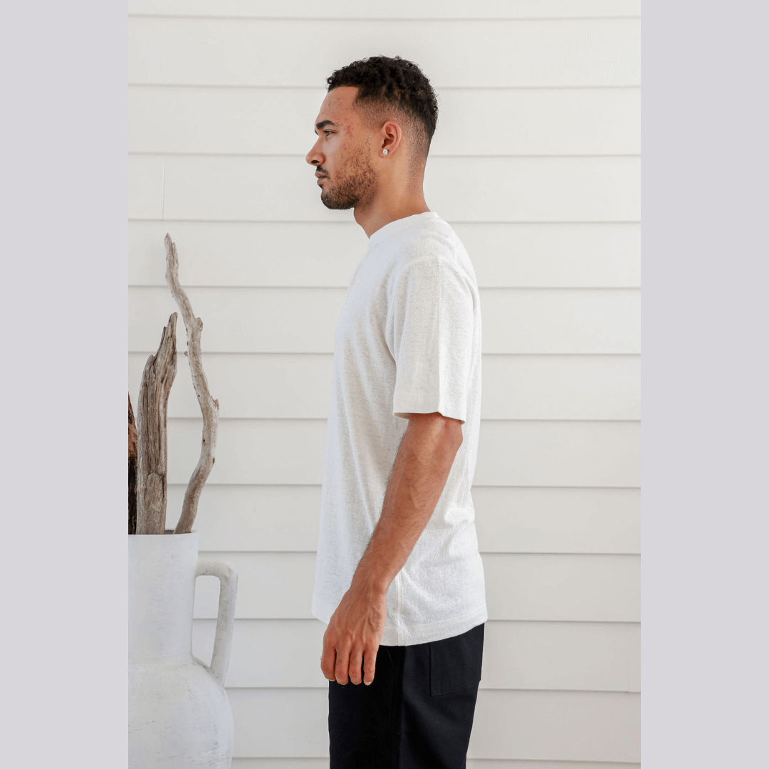 Stewarts Menswear Braintree Hemp. Hemp/Cotton button t-shirt. Hemp/Cotton short sleeve button tee is made from 55% Hemp and 45% Cotton and features a wide placket with two buttons. Photo shows model wearing natural coloured shirt - side view.