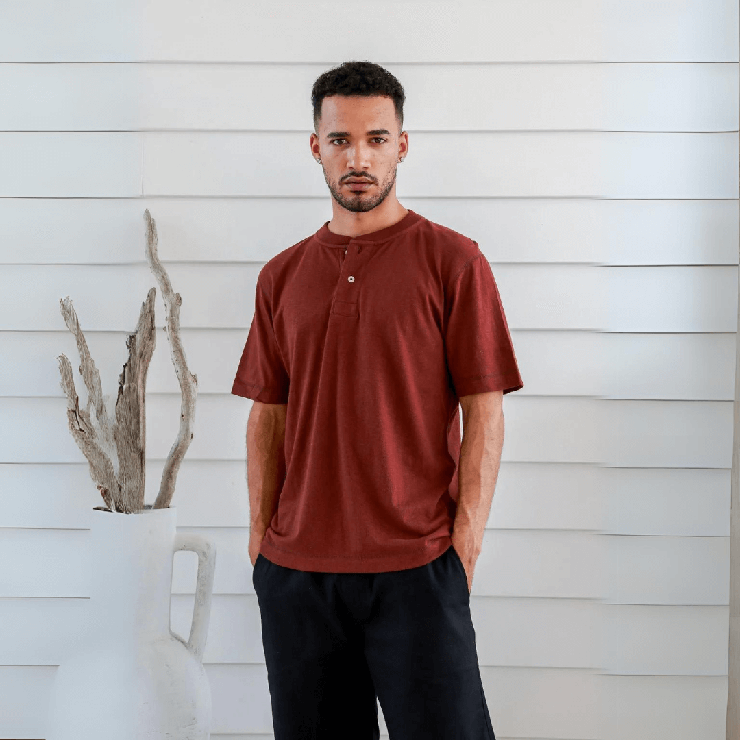 Stewarts Menswear Braintree Hemp. Hemp/Cotton button t-shirt. Hemp/Cotton short sleeve button tee is made from 55% Hemp and 45% Cotton and features a wide placket with two buttons. Photo shows model wearing red shirt - front view.