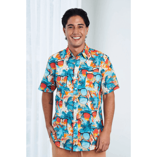 Front view of model wearing Men’s Hemp Cotton Resort Short Sleeve Shirt, natural hemp-cotton blend, available at Stewart’s Menswear Mullumbimby. Brightly coloured sunglasses pattern button through shirt.