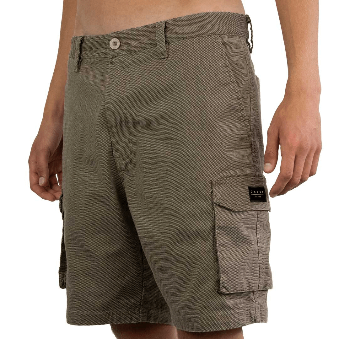 Stewarts Menswear Carve Apex Cargo Short. Made from a cotton/polyester/elastane blend diamond ripstop fabric with heavy garment wash, these cargo shorts are a regular fit with a flat front design and 20" outleg.  The shorts have 2 side angled pockets with contrast printed pocket lining plus a back welt pocket. Colour is stone.