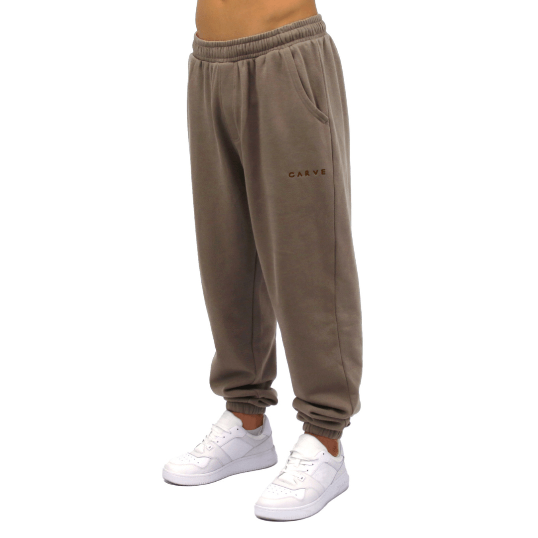 Front view of Carve Bowen Track Pant in driftwood available at Stewart’s Menswear Mullumbimby. Regular fit track pants with elastic waist, ankle cuffs and angled pockets.