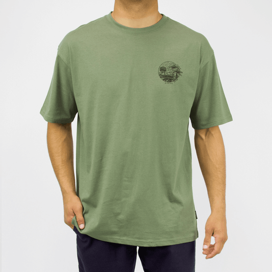 Carve Eventide Short Sleeve Tee is a relaxed cotton T-shirt with chest and back prints, S–5XL, available at Stewart’s Menswear Mullumbimby. Photo shows front view of Eventide T-shirt showing small left chest print. Moss Green Colour with black print.