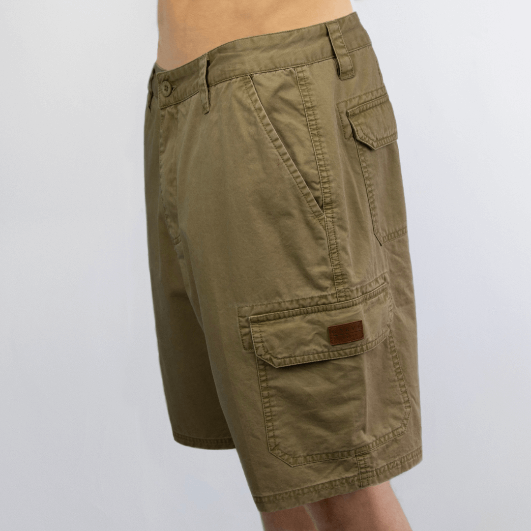 Carve Fort Men’s Cargo Shorts available at Stewart’s Menswear Mullumbimby. Side view of cotton cargo shorts with side, back, and logo badge pocket. Colour is khaki.