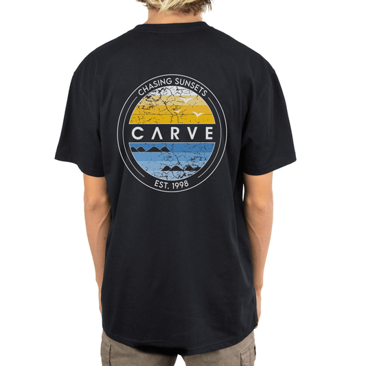 Stewarts Menswear Carve Boys Horizon Tee. This is a regular fit boy's short sleeve T-shirt with small chest print and large back graphic print with the words "Chasing Sunsets Est 1998). Colour is black. Image shows back print.